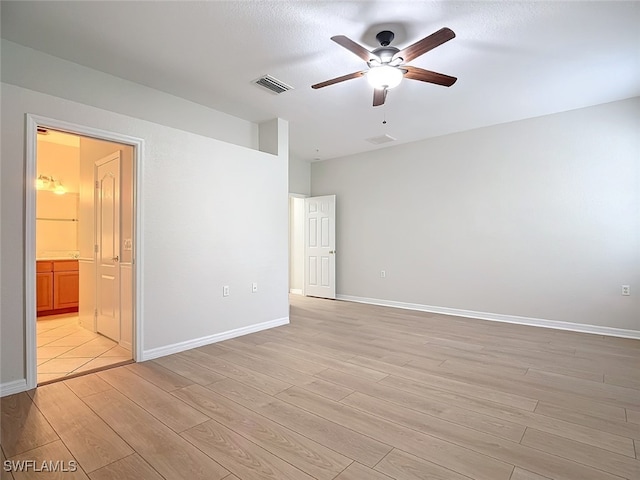 unfurnished room featuring a textured ceiling, light wood-type flooring, and ceiling fan