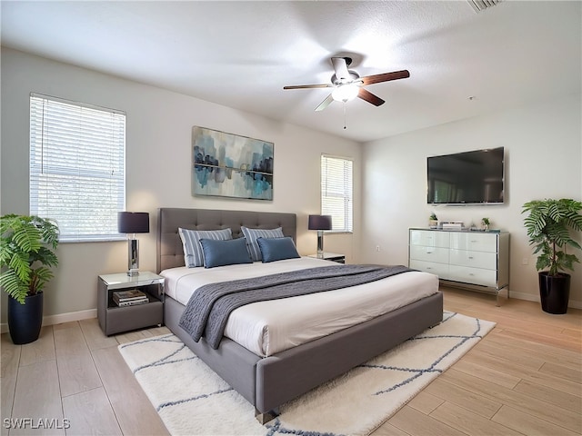 bedroom featuring a textured ceiling, light hardwood / wood-style floors, and ceiling fan