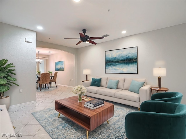 living room with light tile patterned floors and ceiling fan with notable chandelier