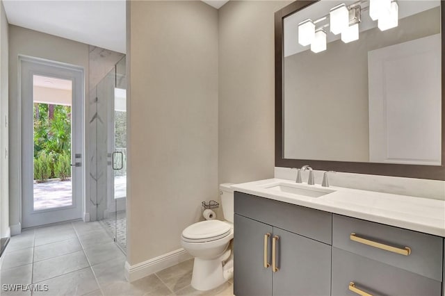 bathroom with tile patterned floors, vanity, toilet, and a shower with door