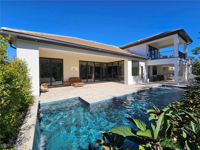 rear view of house featuring a patio and a balcony