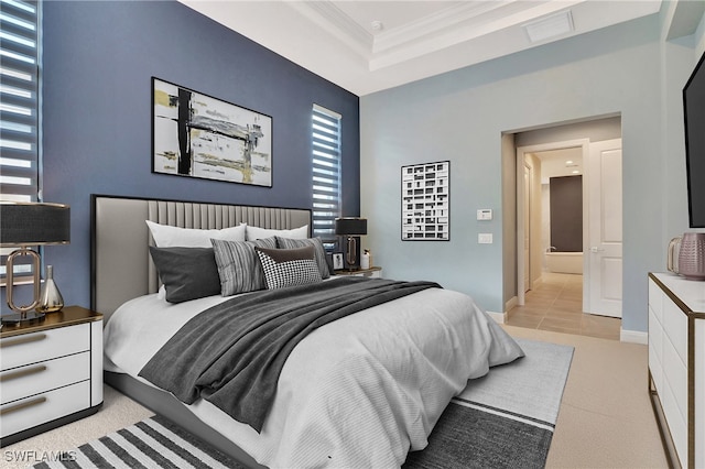 bedroom with a tray ceiling, crown molding, and light colored carpet