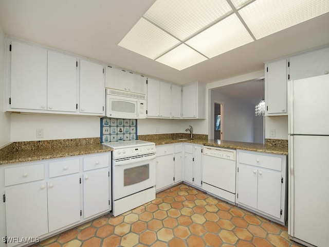 1940A Bald Eagle Dr, Naples, FL 34105 - kitchen featuring dark countertops, white cabinetry, a sink, and white appliances