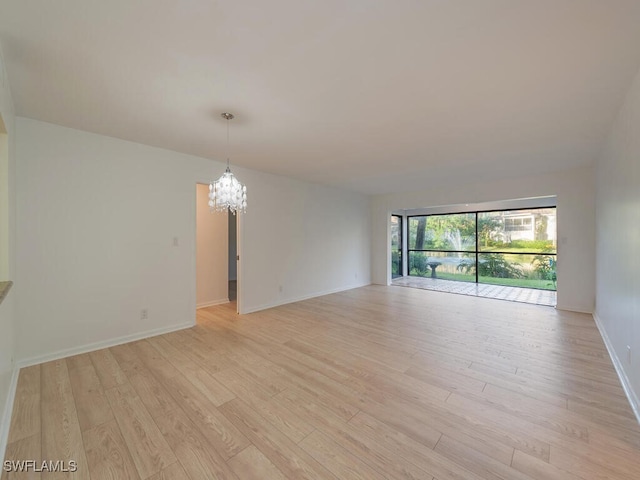 1940A Bald Eagle Dr, Naples, FL 34105 - spare room with light wood-style floors, baseboards, and a notable chandelier