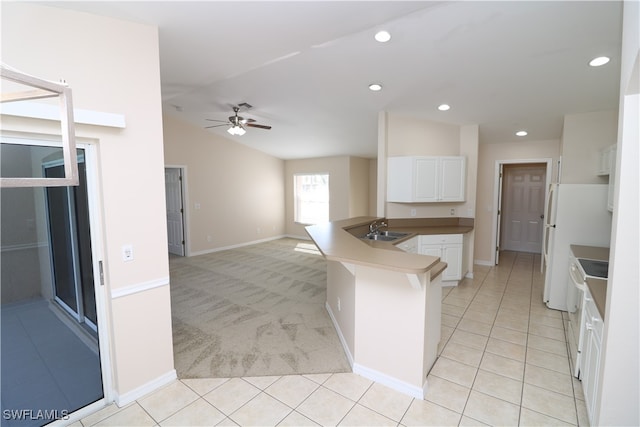 kitchen featuring sink, kitchen peninsula, white cabinetry, ceiling fan, and vaulted ceiling