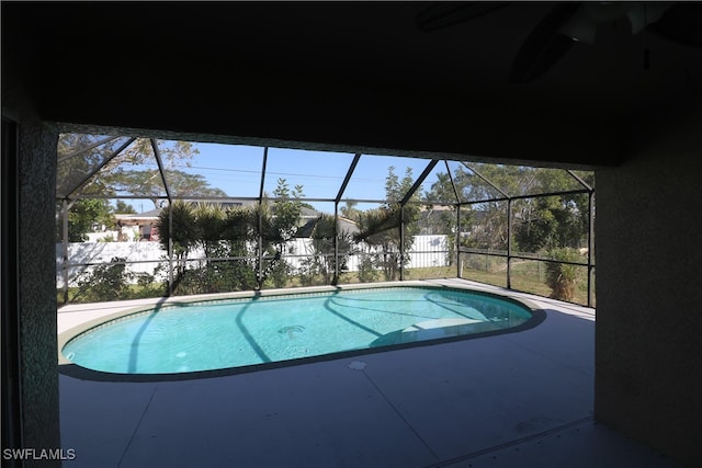 view of swimming pool with a patio area and a lanai