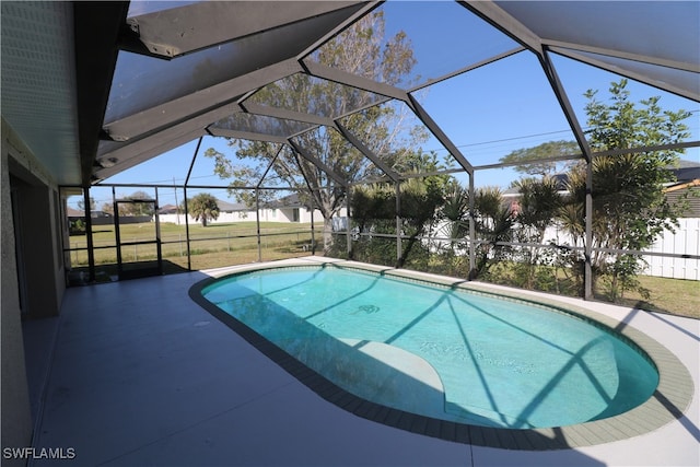 view of swimming pool with a lawn, a patio, and glass enclosure