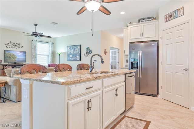 kitchen featuring white cabinetry, appliances with stainless steel finishes, sink, and a kitchen island with sink