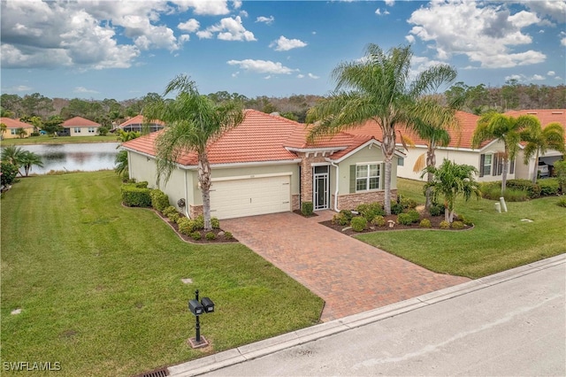 mediterranean / spanish-style house with a garage, a water view, and a front lawn