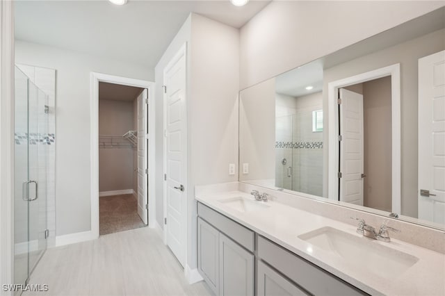 bathroom with a shower with door and vanity