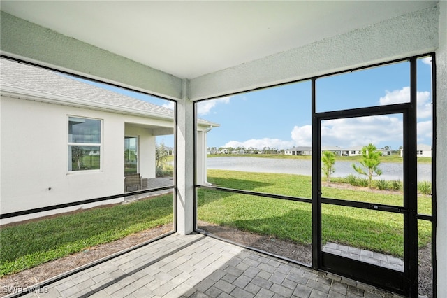 unfurnished sunroom featuring plenty of natural light and a water view