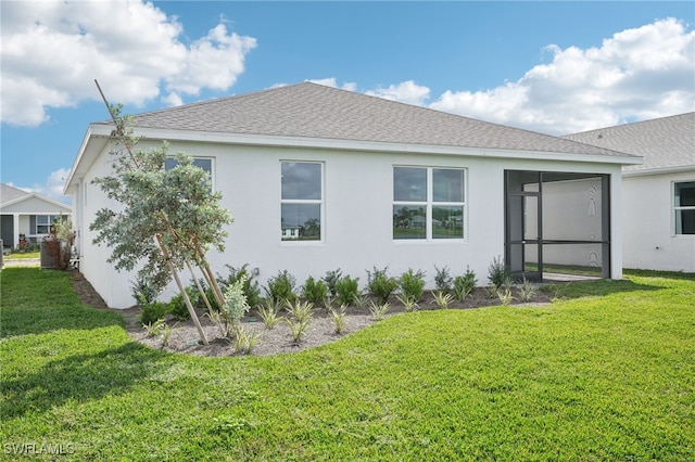 rear view of house featuring a sunroom and a yard