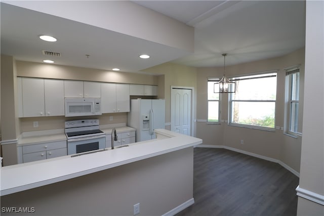 kitchen with an inviting chandelier, white cabinetry, dark hardwood / wood-style floors, pendant lighting, and white appliances