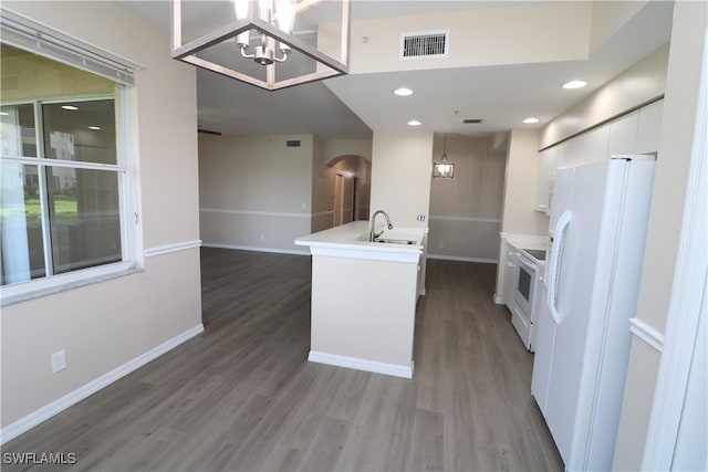 kitchen featuring white appliances, sink, hardwood / wood-style floors, decorative light fixtures, and white cabinets