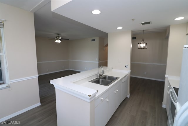 kitchen featuring dark hardwood / wood-style floors, sink, pendant lighting, white cabinetry, and white appliances