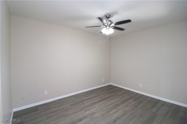 spare room featuring dark wood-type flooring and ceiling fan