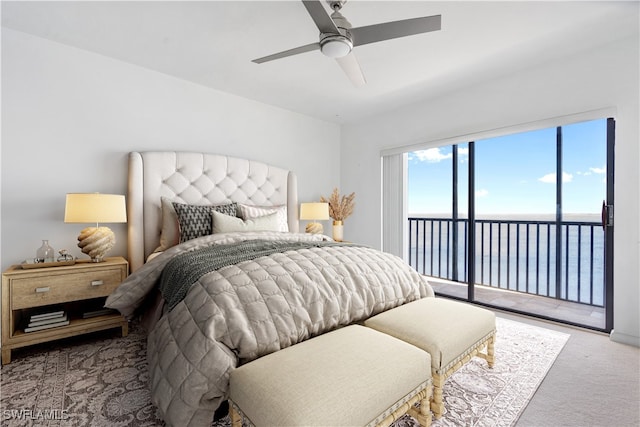 bedroom featuring a water view, light carpet, ceiling fan, and access to exterior