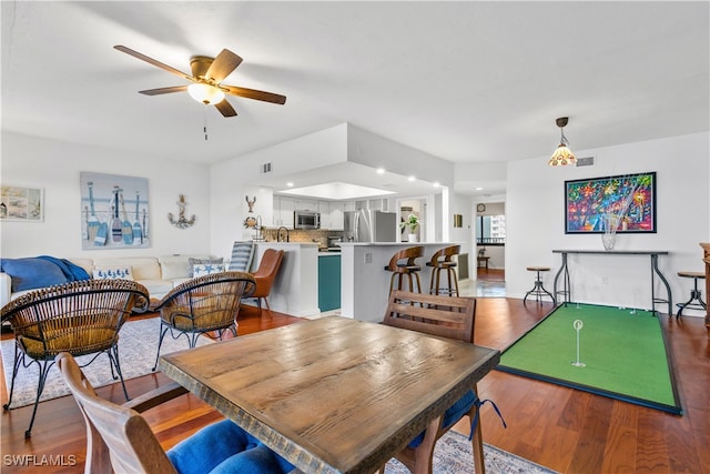 dining area with wood-type flooring and ceiling fan