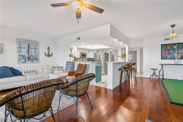 living room with hardwood / wood-style flooring and ceiling fan