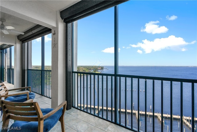 sunroom / solarium with a water view and ceiling fan