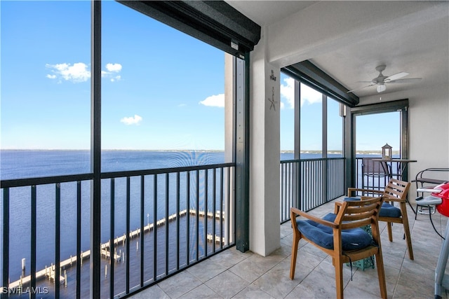 sunroom / solarium with a water view and ceiling fan