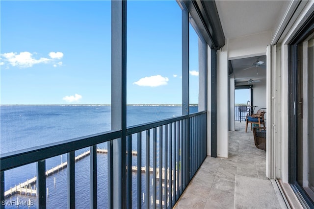 exterior space with a wealth of natural light, a water view, and ceiling fan