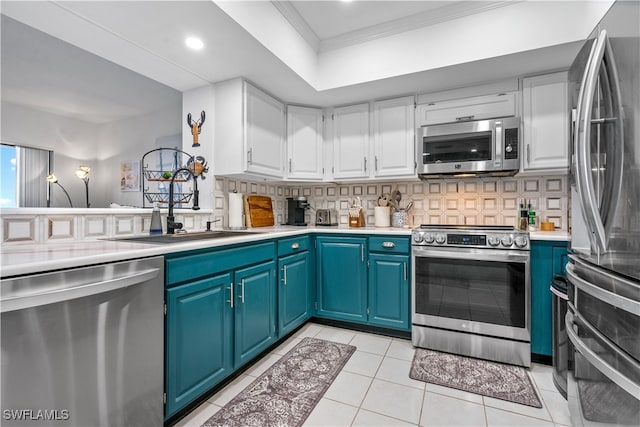 kitchen featuring white cabinets, tasteful backsplash, appliances with stainless steel finishes, ornamental molding, and blue cabinets