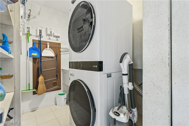 laundry room with stacked washer and clothes dryer and light tile patterned floors