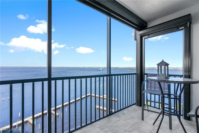 sunroom featuring a water view