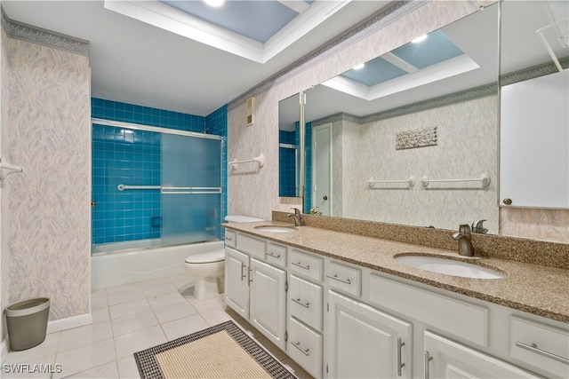 full bathroom with tile patterned floors, toilet, a raised ceiling, vanity, and combined bath / shower with glass door