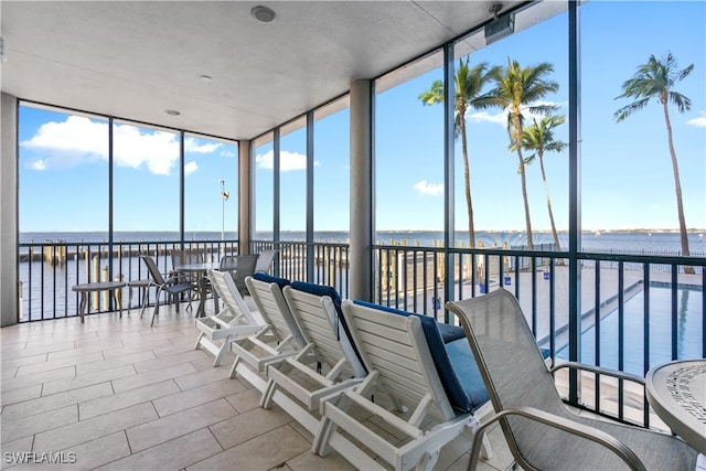 sunroom / solarium with a water view and a wealth of natural light