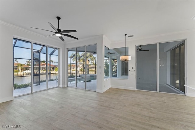 unfurnished room featuring ceiling fan, ornamental molding, and a water view