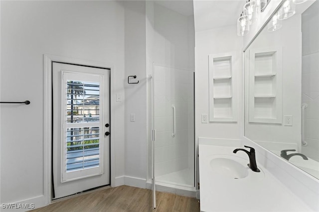 bathroom with vanity, hardwood / wood-style floors, and a shower with door