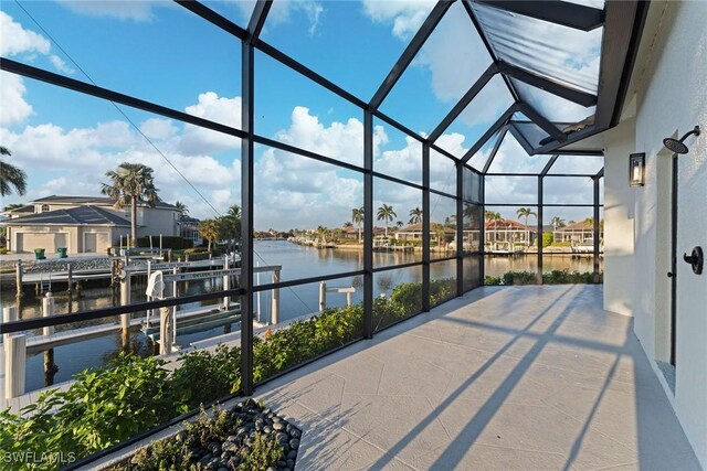 view of patio / terrace featuring a water view, a lanai, and a boat dock