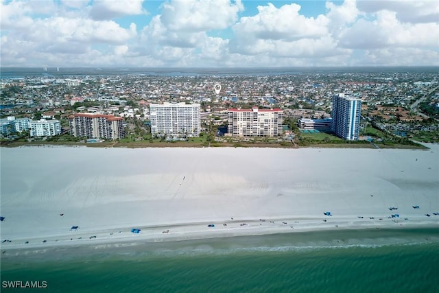 drone / aerial view with a water view, a view of the beach, and a city view