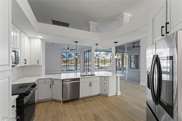 kitchen with kitchen peninsula, sink, light wood-type flooring, white cabinetry, and stainless steel appliances