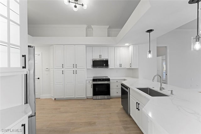 kitchen with sink, white cabinetry, hanging light fixtures, and appliances with stainless steel finishes