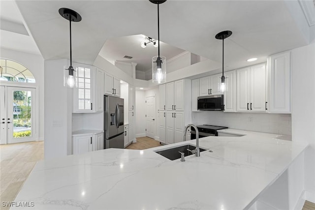 kitchen featuring white cabinets, hanging light fixtures, kitchen peninsula, and appliances with stainless steel finishes