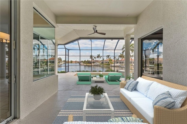 sunroom / solarium featuring ceiling fan and a water view