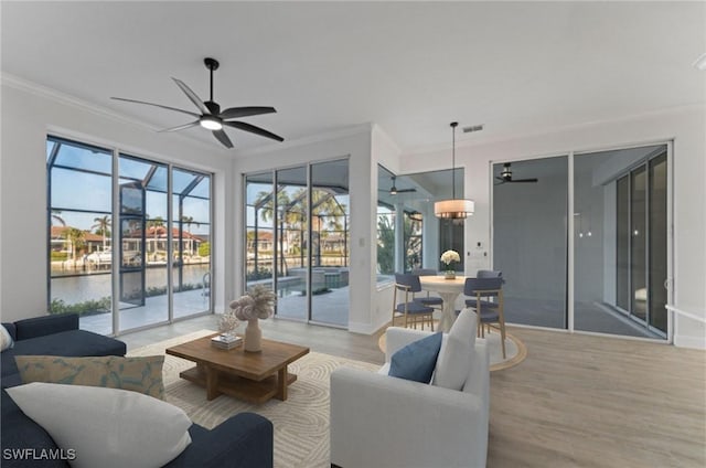 living room with ceiling fan, crown molding, and light hardwood / wood-style floors