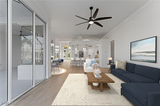 living room featuring light wood-type flooring, ceiling fan, and ornamental molding