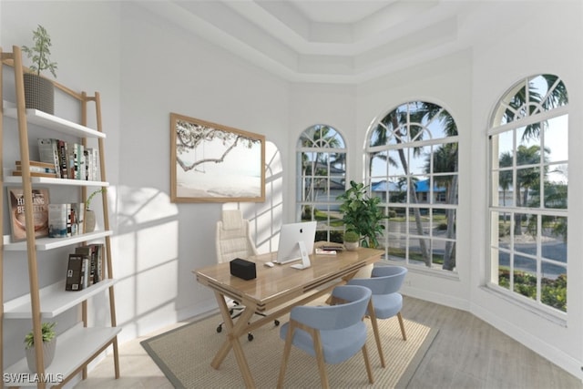 home office featuring a towering ceiling and light wood-type flooring