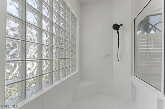 full bathroom featuring a wealth of natural light and tiled shower