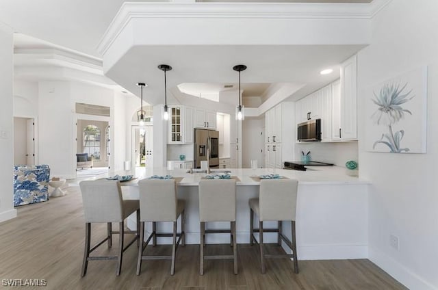 kitchen with stainless steel appliances, light countertops, glass insert cabinets, white cabinetry, and a peninsula