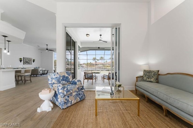 living area with ceiling fan, wood finished floors, and baseboards