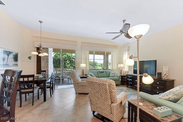 living room featuring ceiling fan with notable chandelier and lofted ceiling