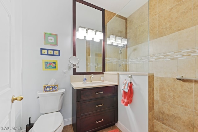 bathroom featuring vanity, toilet, and a tile shower