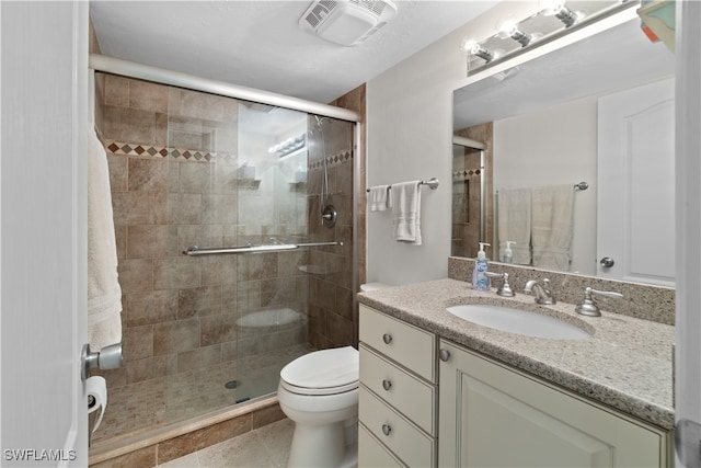 bathroom with toilet, vanity, tile patterned flooring, and a shower with shower door