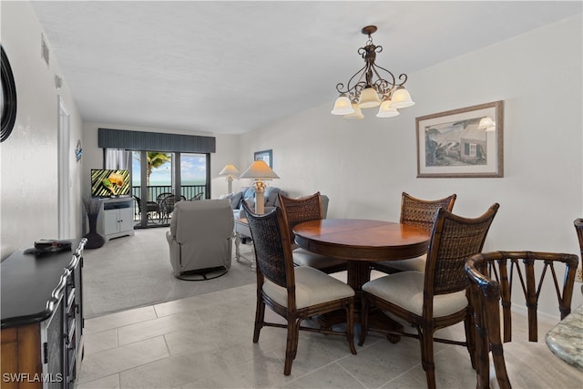 tiled dining area featuring a chandelier