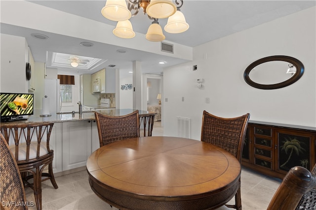 dining area featuring sink, an inviting chandelier, and light tile patterned flooring